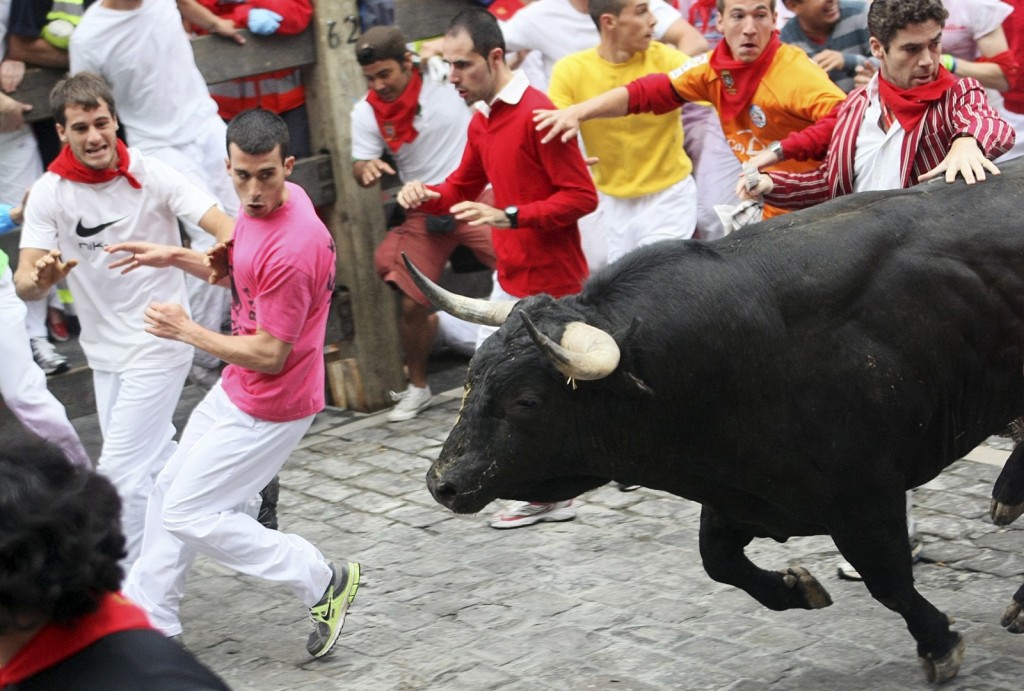 Runners lead a Torrestrella ranch bull during the first bull run of the San Fermin Festival in Pamplona